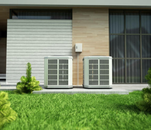 Heat pumps outside the modern house, installed near the wall.